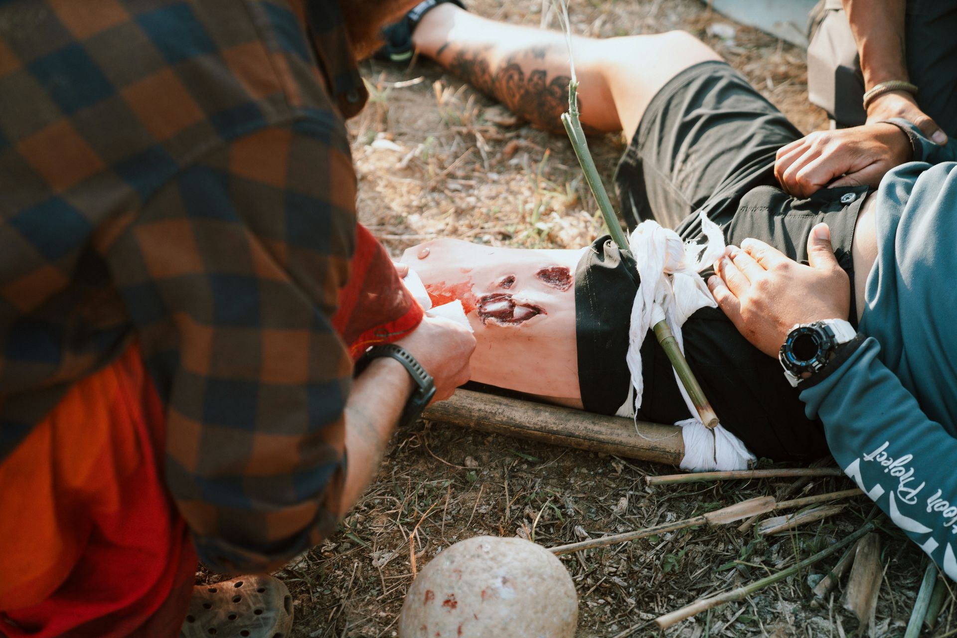 A group of men standing around a man laying on the ground
